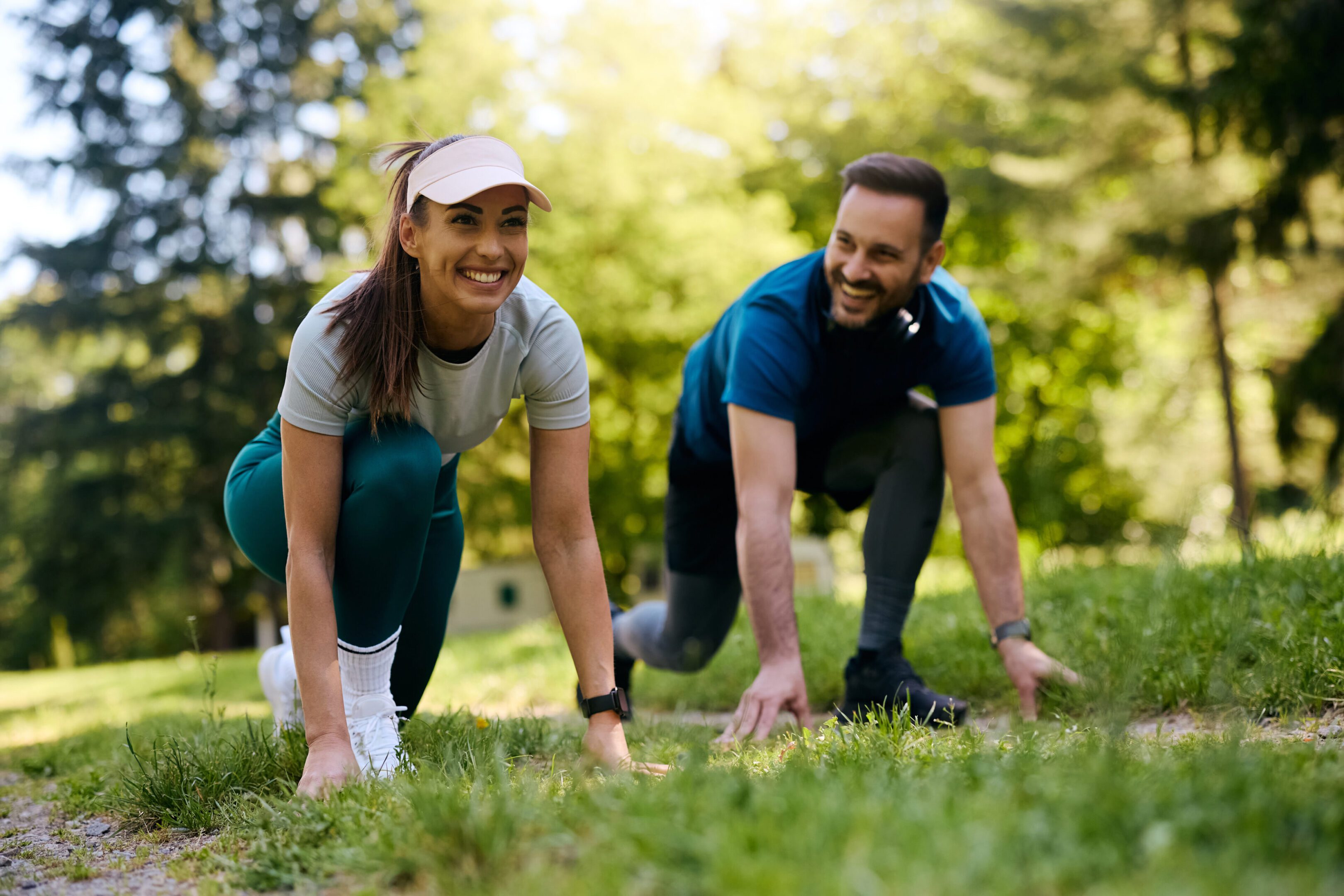 Ready, steady, go! A man and woman are doing push ups in the grass.