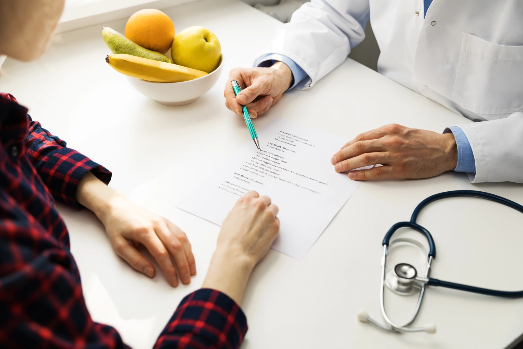 doctor consultation - practitioner and patient discussing diet plan